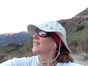 Laurie gazes out at the sky while hiking in the mountains at dawn
